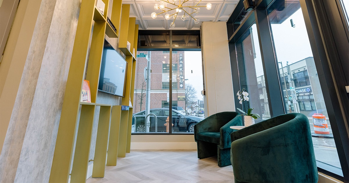 Velvet lounge seating beside floor-to-ceiling windows