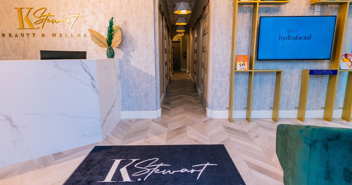 K Stewart Beauty & Wellness reception with marble desk and gold signage